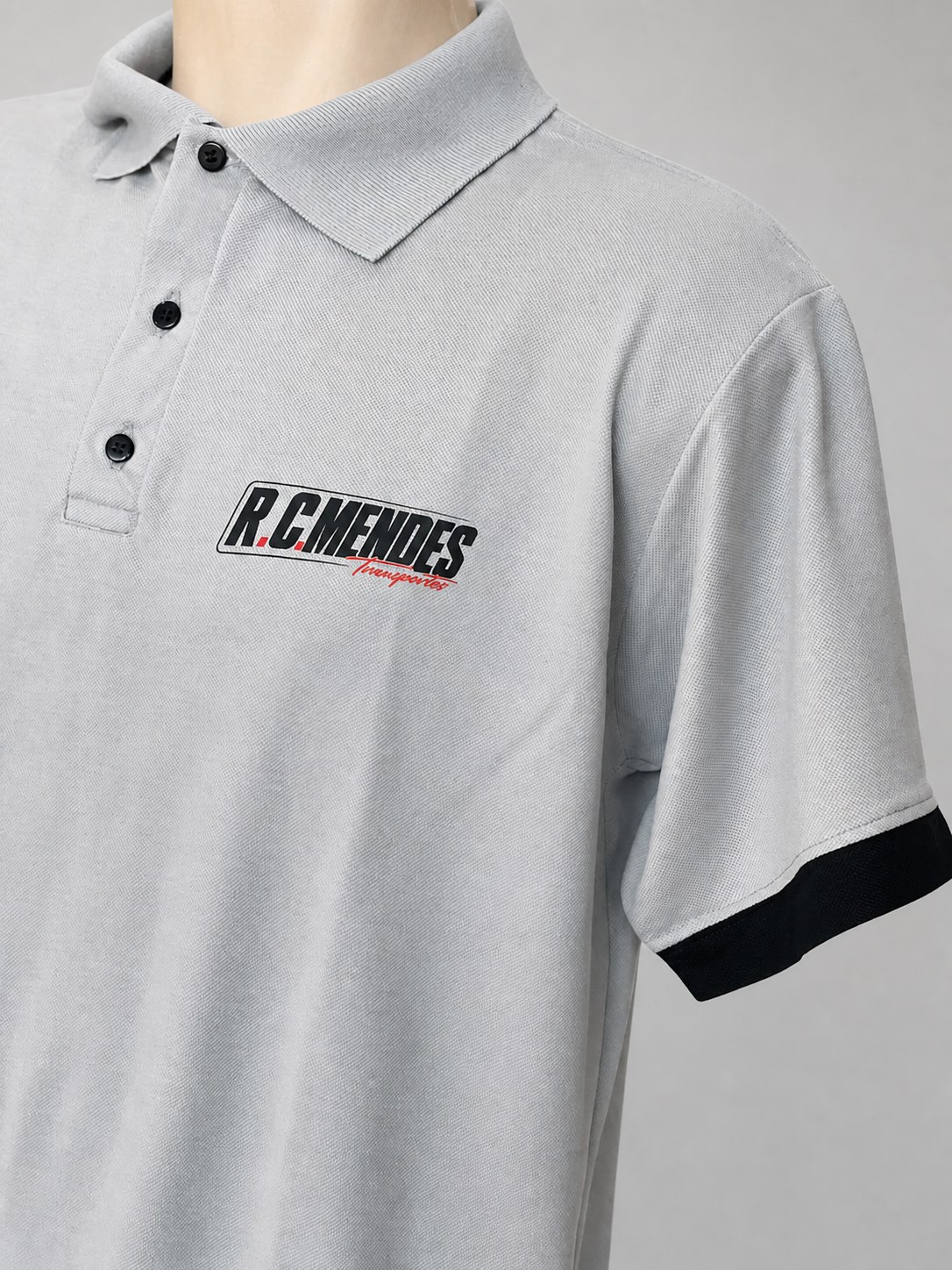 Polo cinza com acabamento preto e aplicação frontal